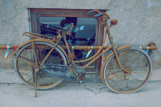 City Riga, Latvian Republic. Rusty bicycle standing on the edge of the street. Travel photo 2019. 25. Jun.