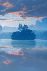 Vertical image of Lake view a Baan Nong Thale in Krabi, Thailand during sunrise with beautiful cloud.