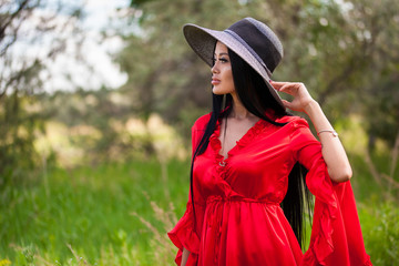 Happy young asian woman in hat on a nature