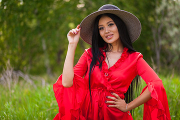 Happy young asian woman in hat on a nature