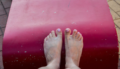 a beautiful pedicure and female feet on a red background