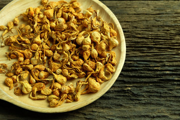 Dried cordyceps militaris in wooden dish on old wooden floors