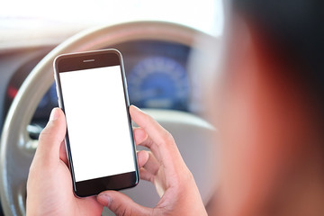 Cropped shot view The driver uses the phone while driving. Modern smart phone with round edges. Isolated screen for mockup. Car navigation display in background.