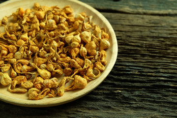 Dried cordyceps militaris in wooden dish on old wooden floors