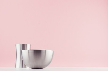 Trendy hi-tech decor for interior - elegant silver polished abstract decoration on white wood shelf and soft light pink background.