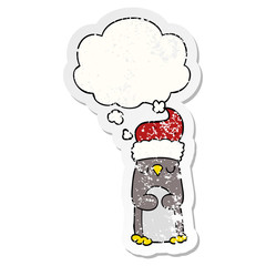 cartoon christmas penguin and thought bubble as a distressed worn sticker