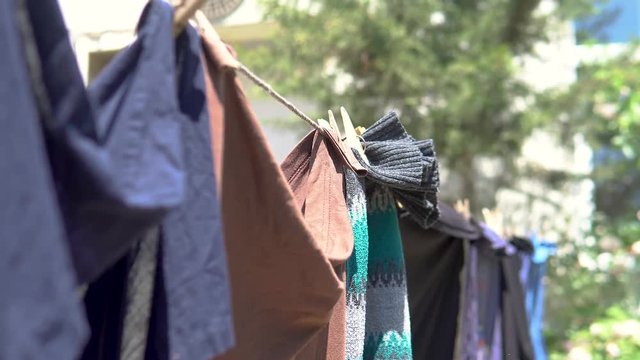 Clean Washed Clothes hanged on wire with clothes peg and blurred Spring Nature background in village.