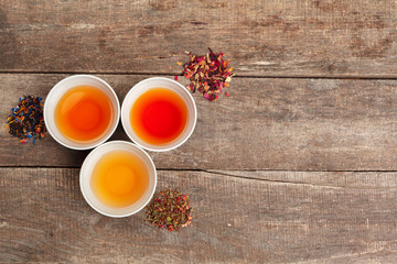 Collection of different teas in cups with tea leaves