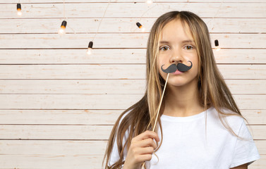 Lovely little girl in a  with funny photo props paper. Happy kid © fotofabrika