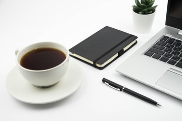 Modern office desk workspace with coffee cup, notebook, laptop and succulent with copy space on white background. Top view. Flat lay. Education, freelance and business concept