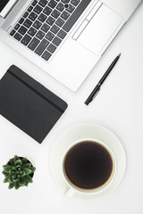 Modern office desk workspace with coffee cup, notebook, laptop and succulent with copy space on white background. Top view. Flat lay. Education, freelance and business concept