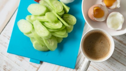 Boiled eggs with fresh cucumber salad and coffee cup breakfast set - top view breakfast food concept