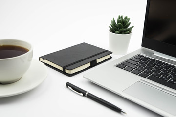 Modern office desk workspace with coffee cup, notebook, laptop and succulent with copy space on white background. Top view. Flat lay. Education, freelance and business concept
