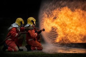 2 firefighters spraying water in fire fighting operation, Fire and rescue training school regularly...