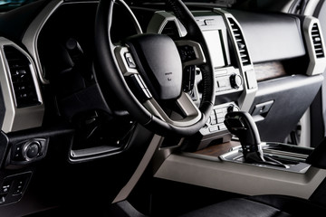 New car interior with luxury details, automatic transmission and steering wheel with electric...