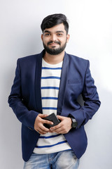 Portrait of a young Indian successful businessman wearing suit over white background