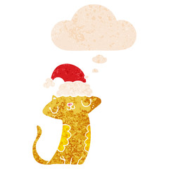 cute cartoon cat wearing christmas hat and thought bubble in retro textured style