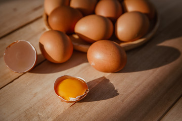 Eggs lay on wooden trays and have broken eggs.