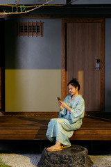 Lifestyle series: Asian woman using mobile phone in ryokan
