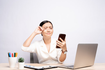 Portrait of sad woman used smartphone at office isolated over background