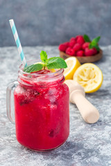 Refreshing raspberry, lemon and mint lemonade with sparkling water in a jar, vertical