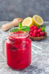 Fototapeta na wymiar Refreshing raspberry, lemon and mint lemonade with sparkling water in jar, vertical