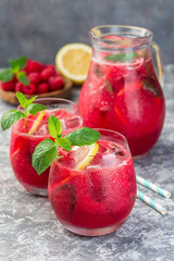 Refreshing raspberry, lemon and mint lemonade with sparkling water in  glass, vertical