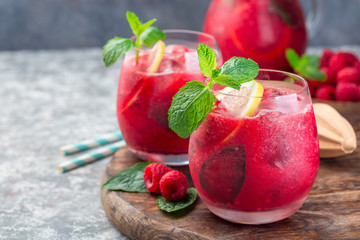 Refreshing raspberry, lemon and mint lemonade with sparkling water in  glass, horizontal, copy space