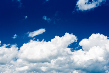 Obraz premium Beautiful white cumulonimbus clouds against the background of the bright blue sky