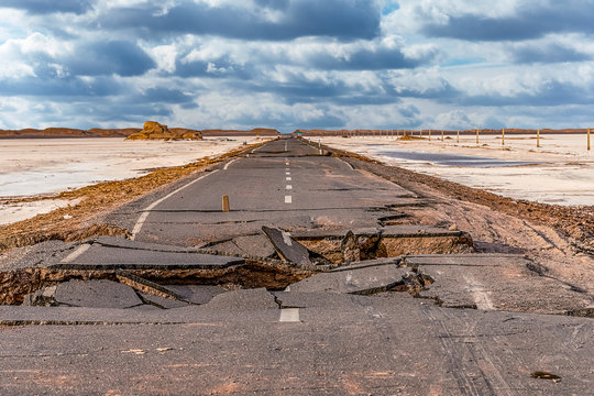.broken asphalt road with cloudy sky in the middle of the  Lut desert,hottest desert in the world, also known like Kalut Desert