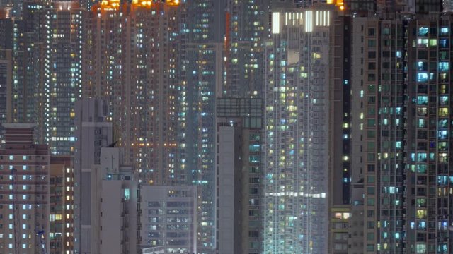 Day to night transition timelapse of Hong Kong apartment buildings. Chinese crowded city with lights turning on and off at midnight. Fast paced modern Asian night-scape time lapse in urban metropolis.