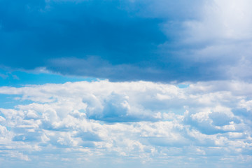 Fototapeta premium Beautiful white cumulonimbus clouds against the background of the bright blue sky
