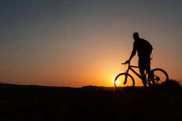 Obraz na płótnie Canvas Man with mountain bike at sunrise