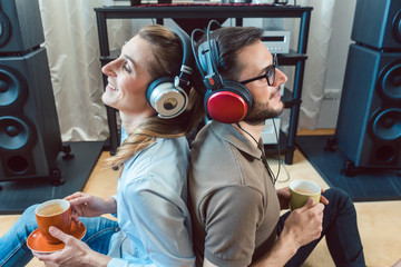Couple with headphones enjoying music from the Hi-Fi stereo