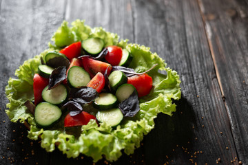 a plate of delicious spring salad with vegetables and green leaves, olive oil, spices