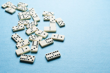 White domino pieces on bright blue background with copy-space for text.