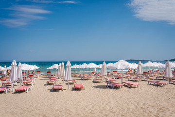 Summer beach with deck chairs and umbrellas. 