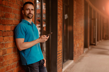 Obraz premium Portrait of modern young man with mobile phone