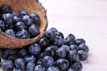Tasty blueberry berries in a bowl on a white wooden table. place for text.