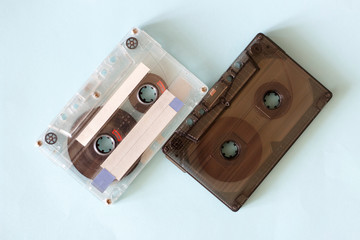 Two retro audio cassettes, close-up on a blue background, vintage concept.