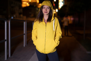Sport woman portrait in yellow windbreaker at the night city © antgor