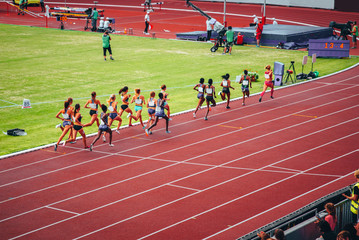 Female track and field race at athletics stadium. Professional female runners. Photo for athletics competition at summer olympic game Tokyo 2020.