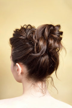 Rear view of female hairstyle medium bun on long straight brown hair with radical volume
