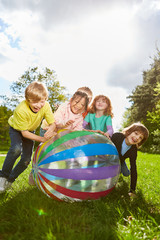Gruppe Kinder spielt ausgelassen mit einem Ball