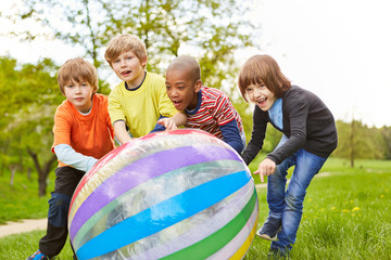 Vier Freunde rollen zusammen eine bunten Ball