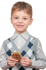 Funny little boy eating Kozinaki - bar of sunflower seeds in a sweet molasses. Child isolated on white background, close up portrait.