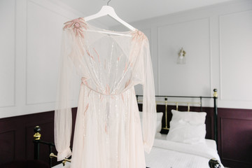 White wedding dress hanging in the bedroom. White bride dress
