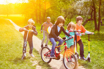 Spielende Kinder fahren mit Roller und Fahrrad