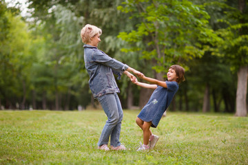 Fototapeta premium Matka i córeczka bawią się razem śmiejąc się latem na świeżym powietrzu