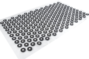 Acupuncture orthopedic massage mat with needles and spikes for feet and body isolated on white background. Alternative medicine, health care, recreation and muscle relaxation concept.